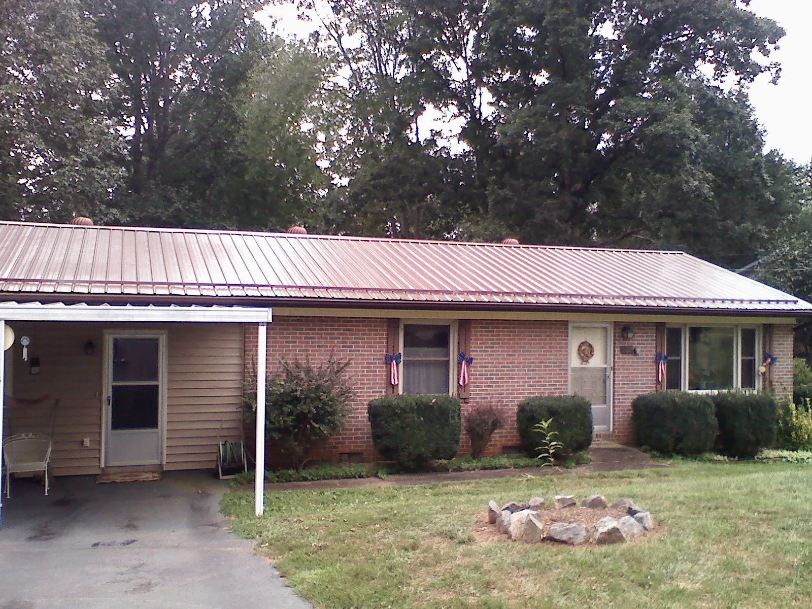 Bronze metal roof and carport on a brick ranch home — Roof Repair work by our crew in Jessieville